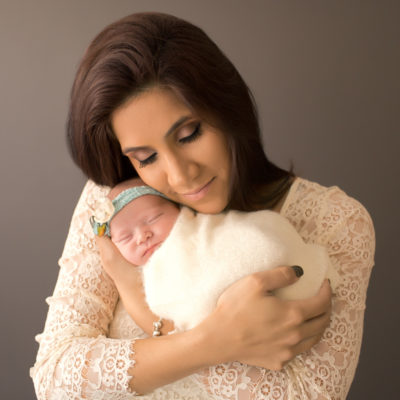 Baby girl Charleigh and Mom eyes closed in lace cudding newborn in Gainesville Florida