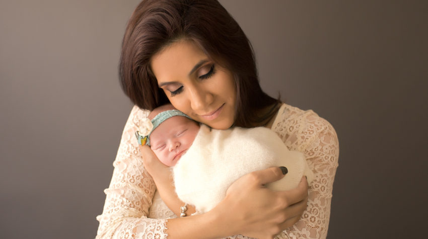 Baby girl Charleigh and Mom eyes closed in lace cudding newborn in Gainesville Florida